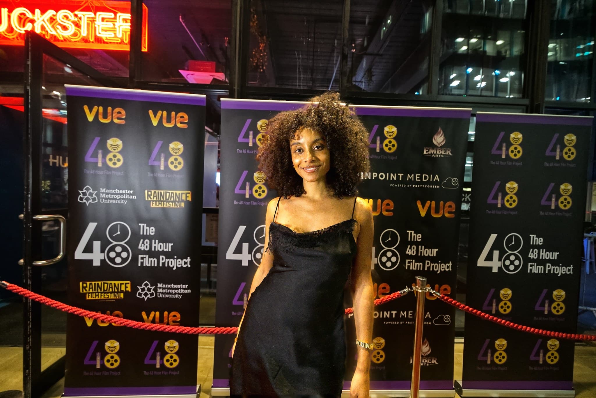 Red carpet portrait of a guest in a black dress at the 48 Hour Film Project London awards night, Paddington Central